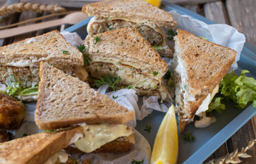Fish cake sandwiches made with whole wheat toast, cheese, tartare sauce, and lettuce