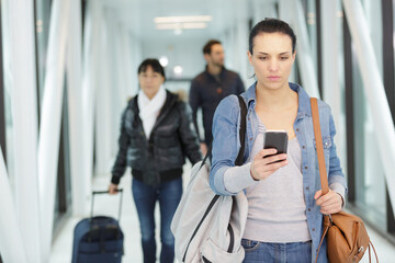 serious woman using smartphone at airport