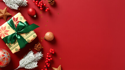 Christmas holiday background with gift boxes, baubles, red berries, snowy fir branches on red. Flat lay, top view, copy space.