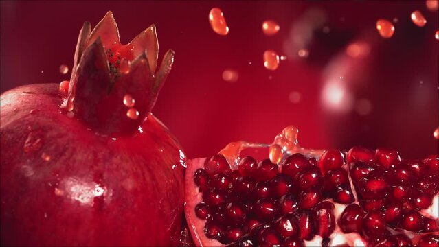 Slow Motion Shot of Pomegranate Juice Splashing through Pomegranate Slices