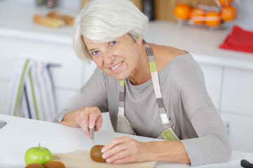 Obraz na płótnie Canvas portrait of senior lady cutting vegetables