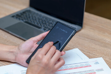 A businesswoman is transferring money using a financial app in her office.