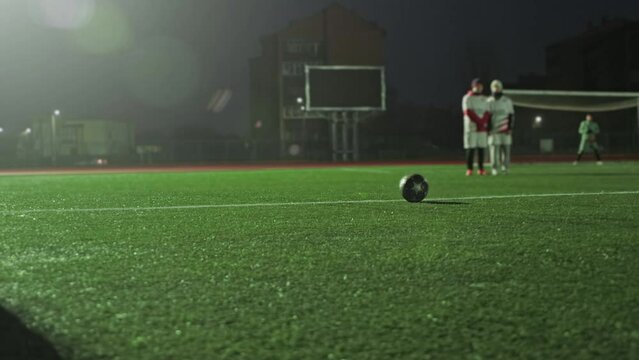 Amateur Semi-professional Soccer Game At Night In Small Stadium. Defensive Wall, Player Is Preparing To Make Direct Free-kick Near Penalty Area. Football. Teams In Uniform Are Playing Friendlie Match