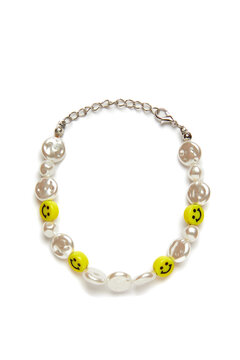 Detail shot of a shiny bracelet made out of pearl beads and yellow smileys. The stylish elegant bracelet with a lobster clasp is isolated on the white background.