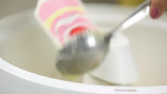 close up of woman's hand putting emulsifier into cake mixer
