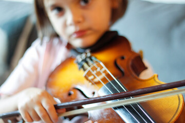 little girl learning to play the violin

