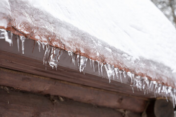 Beginning of spring.Close-up of melting snow icicles on roof.