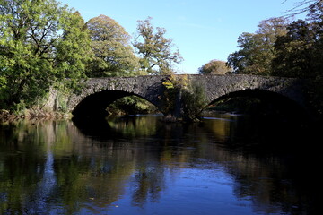 Fototapeta na wymiar Old stone bridge carrying the A6 main road North over the River Kent in Cumbria, UK.