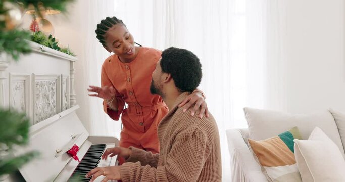 Christmas, piano music and couple singing festive holiday song, having fun and enjoy bonding quality time together. Love, smile and happy black woman and man play musical instrument and celebrate