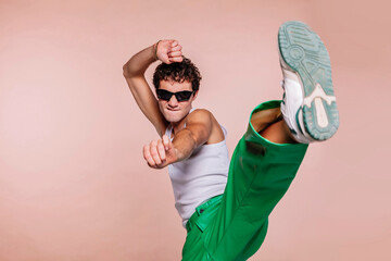 Portrait of handsome guy, throwing high kick in the air, practicing self defense kicking confident...