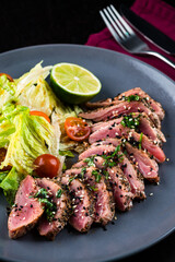 Juicy steak medium rare beef with green salad on plate