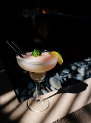 Tropical cocktail on a background of tropical plant leaves and sun shades. on a background of tropical plant. Color background