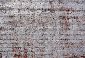 Faded white painted brick wall including brick arch