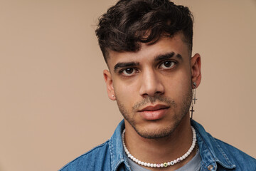 Young handsome stylish man with piercing looking at camera