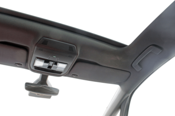 Looking up from inside a modern car through a sun roof and windows.