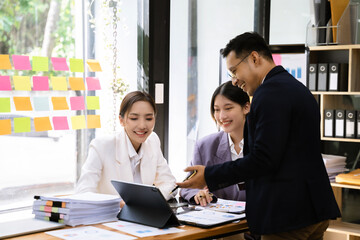 Group of Young Asian business team creative businesspeople coworker in office. Meeting Presentation for analysis graph company financial.