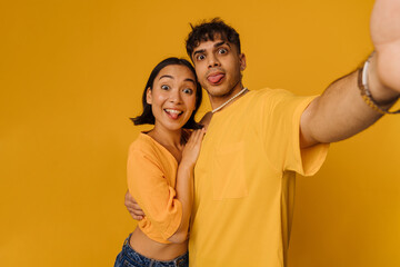 Fototapeta premium Selfie of young beautiful funny couple showing tongues