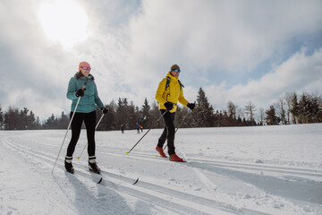 Senior couple skiing together in the middle of forest