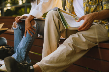 Multiracial friends doing homework together in skate park