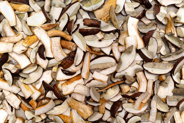 Background of sliced and raw edible mushrooms, lying on baking paper, top view.