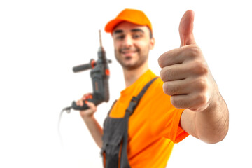 Young worker, thumb up, drilling with electric drill in his hands in blur. Craftsman repairman wearing orange uniform cap and t-shirt, overalls on a white isolated background for advertising.