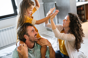 Young family being playful at home. People parent child fun happiness concept.
