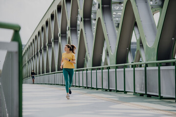 Young woman jogging at city bridge, healthy lifestyle and sport concept.