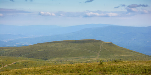 sunset scenery in carpathian mountains. grassy hill in evening light. view in to the distant valley...