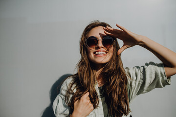 Naklejka premium Portrait of happy young woman outdoor with backpack and sunglasses.