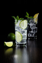 Mojito or virgin mojito long rum drink with fresh mint, lime juice, cane sugar and soda. Black background.