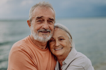 Portrait of senior couple in love, standing and hugging outdoor in nature.