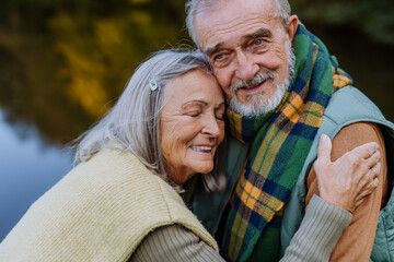 Senior couple in love huging each other in autumn nature.