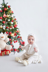 Obraz na płótnie Canvas Santa baby. Christmas tree background. Happy New Year! Child in knitted suit
