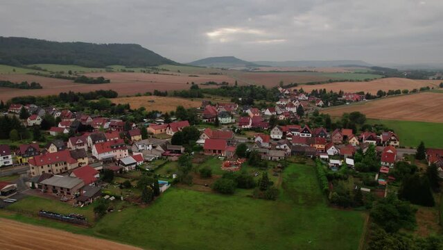 Aer ial view of a German village surrounded by meadows, farmland and forest in Germany.