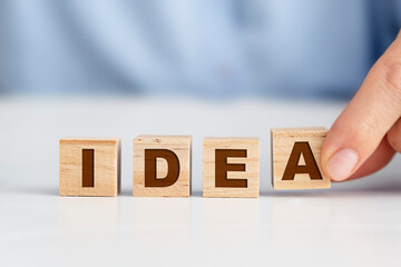 Businesswoman placing wooden blocks, "idea" concept