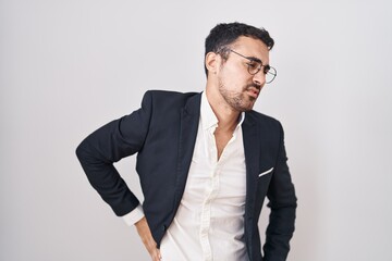 Handsome business hispanic man standing over white background suffering of neck ache injury, touching neck with hand, muscular pain