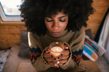 Portrait girl with afro hair style holding a candle at christmas time
