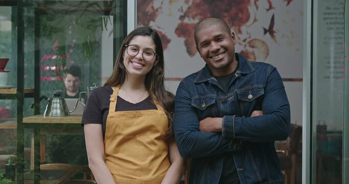 Two happy employees of local small business shop. Young diverse millennials entrepreneurs posing together at camera with arms crossed