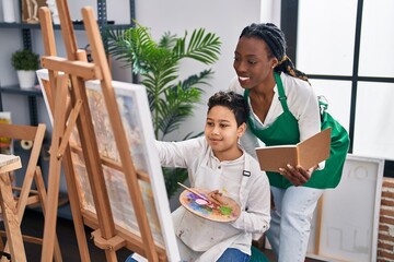 African american mother and son art student and teacher having draw lesson at art studio