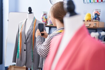 Young blonde woman tailor make photo to manikin at tailor shop