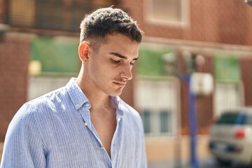 Obraz premium Young hispanic man with relaxed expression standing at street