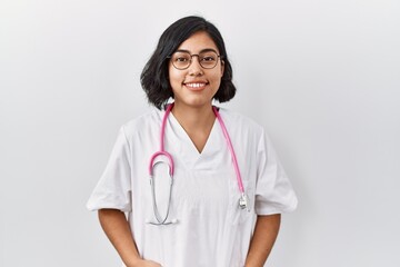 Young hispanic doctor woman wearing stethoscope over isolated background with a happy and cool...