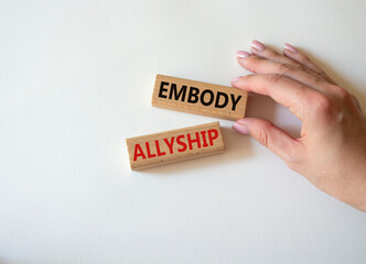 Embody Allyship symbol. Concept word Embody Allyship on wooden blocks. Beautiful white background. Businessman hand. Business and Embody Allyship concept. Copy space