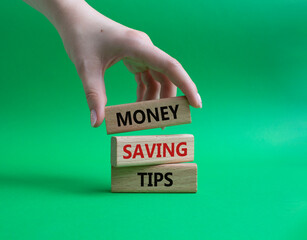 Money saving tips symbol. Concept words Money saving tips on wooden blocks. Beautiful green...