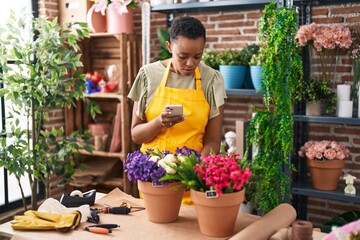 African american woman florist make photo to plant by smartphone at florist