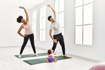 Obraz premium Couple and daughter stretching at sport center