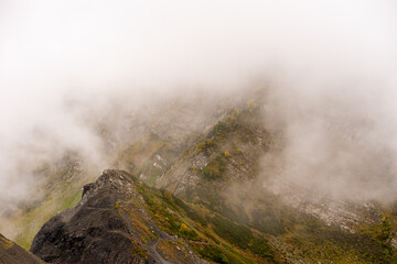 Mountain range with visible silhouettes through the morning colorful fog.