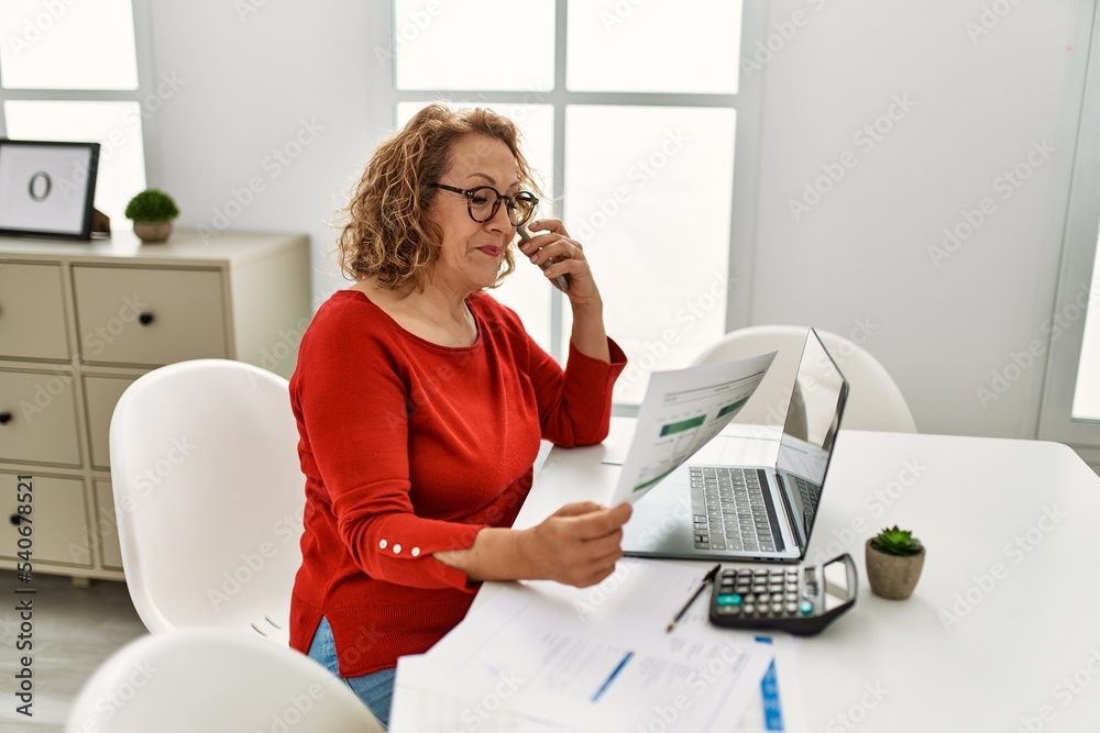 Sticker middle age caucasian woman talking on the smartphone working at home.