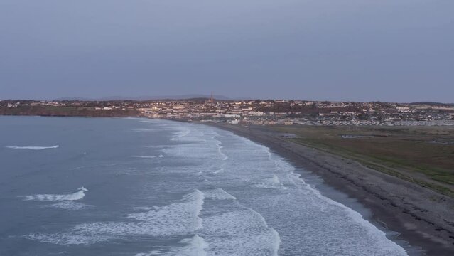 Dawn aerial along Tramore Strand toward seaside coast town in Ireland