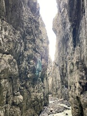 Rocky canyon in the Switzerland. Big rocks and boulders in the canyon. Summer day with blue sky canyon with green forest on the top. Huge canyon with river and waterfalls inside.
